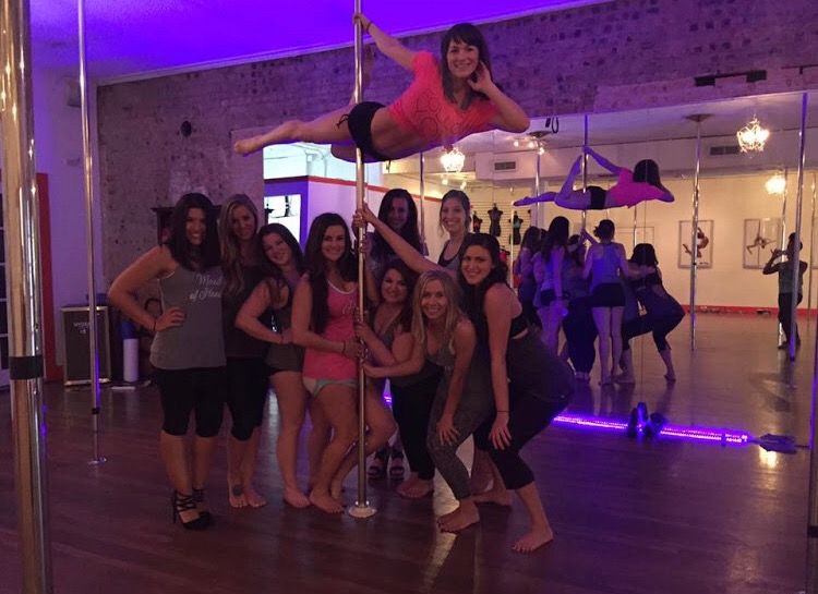 Aerialist performing above a class group in purple studio light